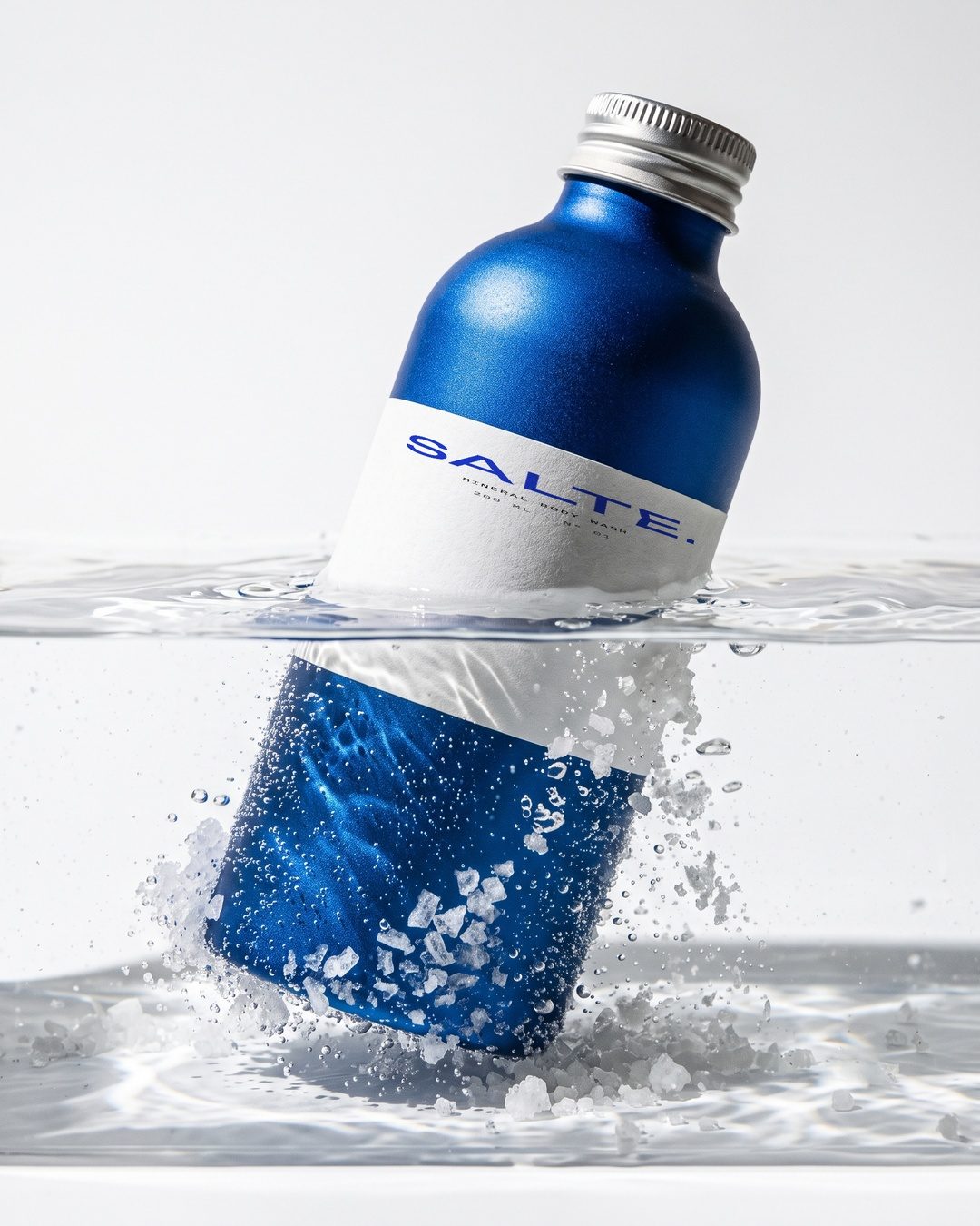 SALTE bottle splashing into water with salt crystals